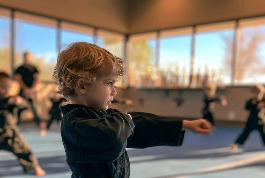 Preschooler in a gi throwing a focused punch during a Kosho Cubs martial arts class at James Martial Arts Academy in El Cajon